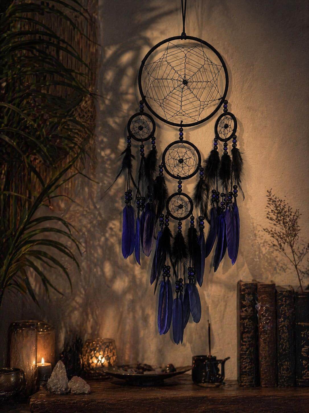 Decorative dreamcatcher with blue feathers on a mystical table setting.