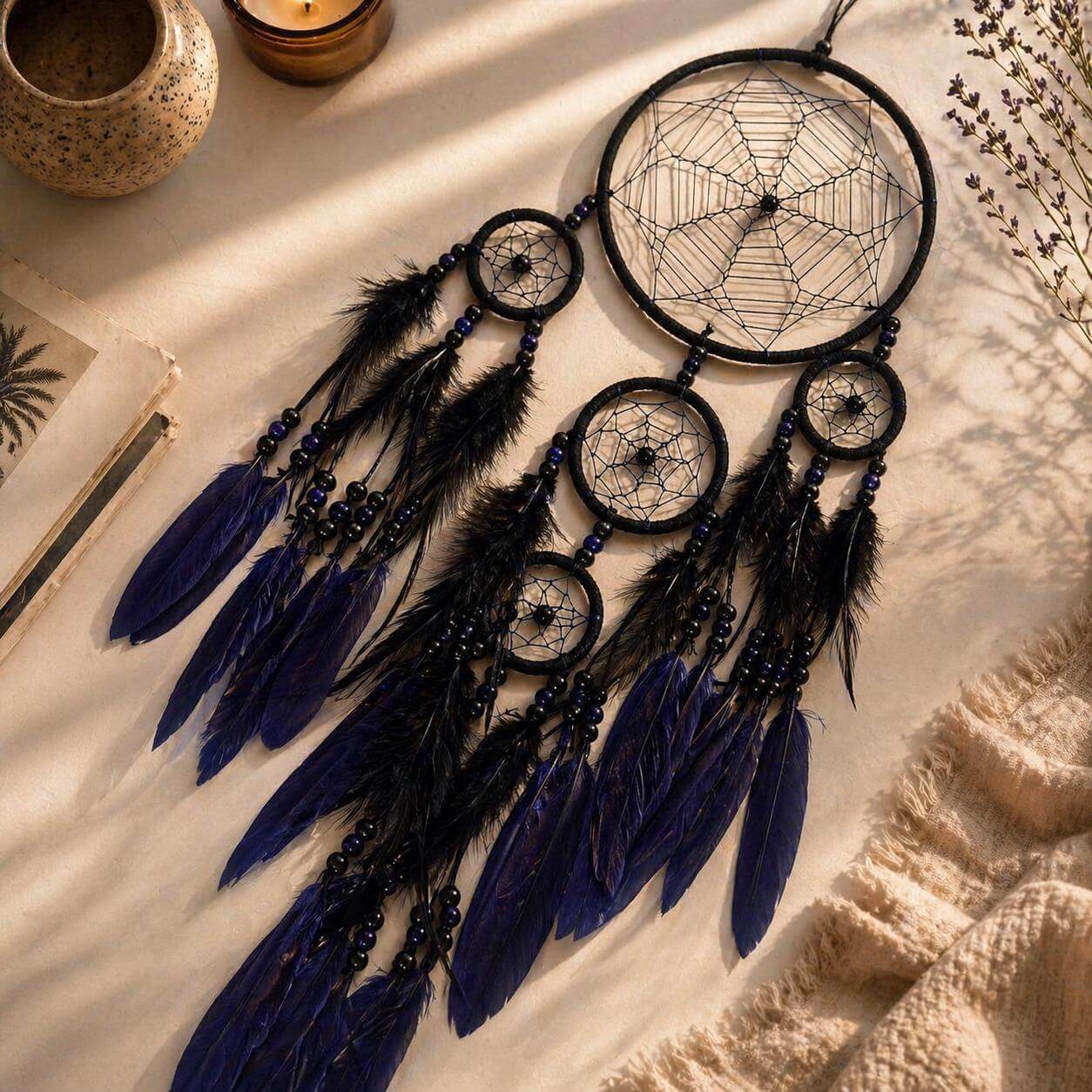 Black and blue dreamcatcher with feathers on a textured surface