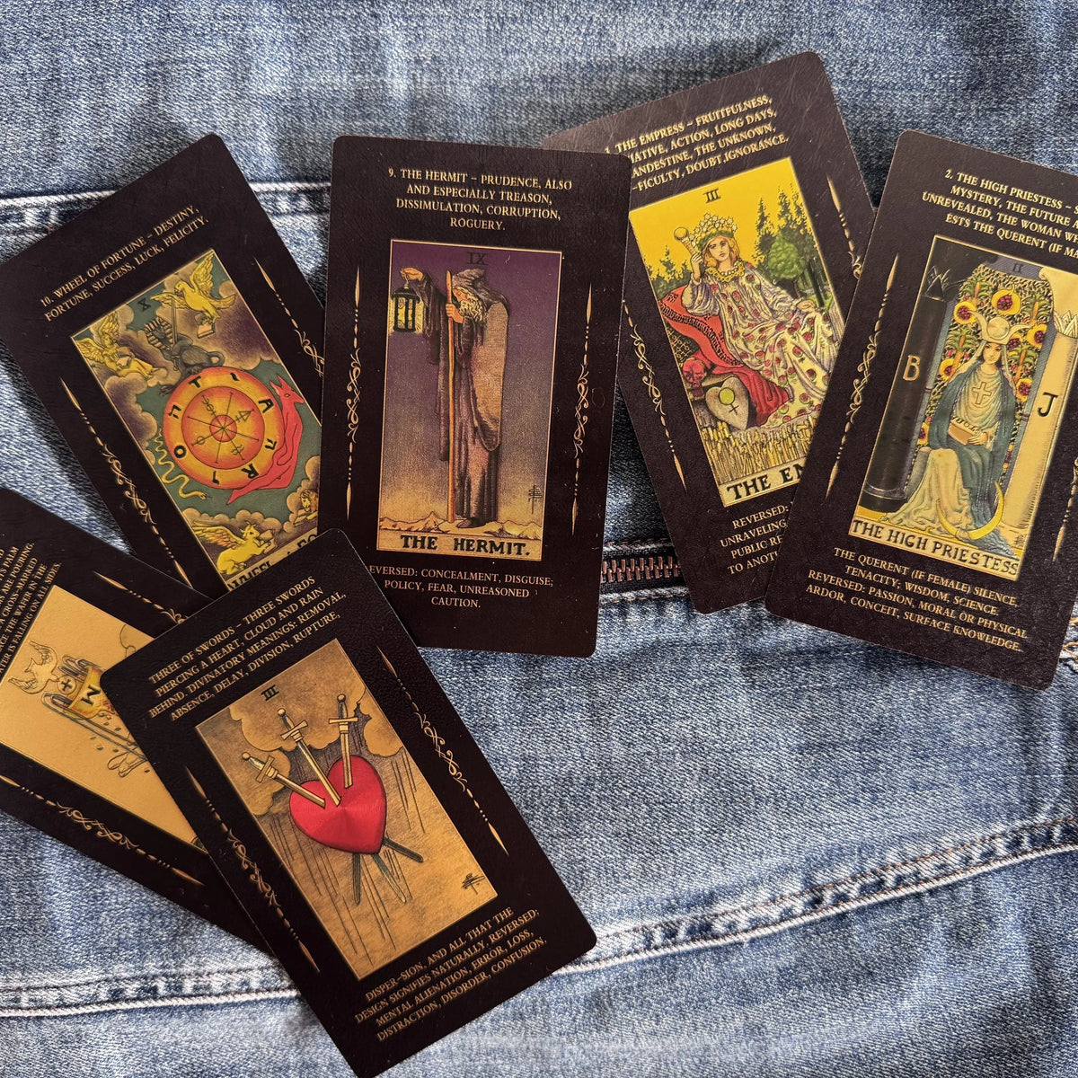 Collection of tarot cards on a denim surface