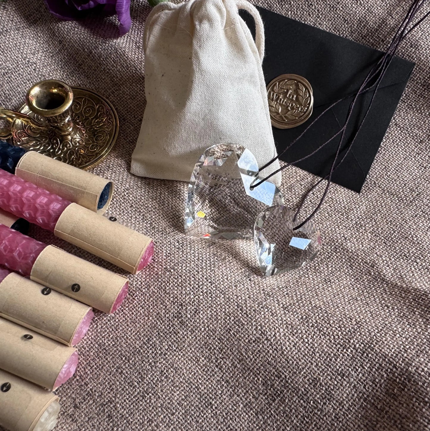 Crystal, natural beeswax candles on a textured surface