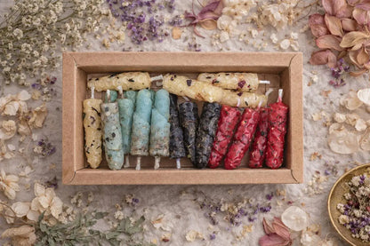Set of colorful  natural beeswax candles in a wooden box on a floral background