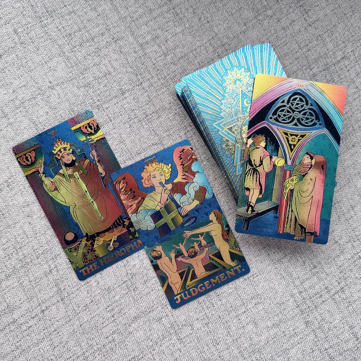 Colorful tarot cards on a textured gray surface
