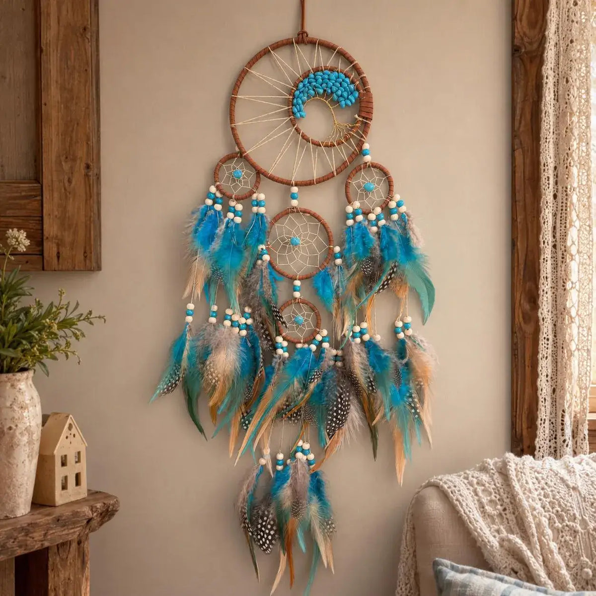 Decorative dreamcatcher with blue feathers hanging on a wall.