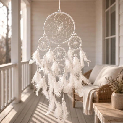 White dreamcatcher with feathers hanging on a porch