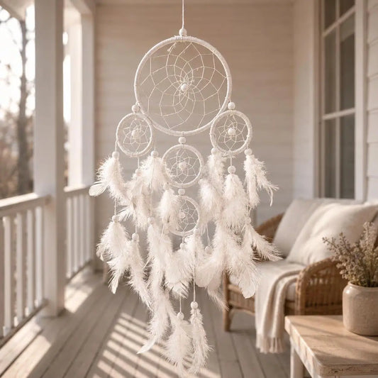 White dreamcatcher with feathers hanging on a porch