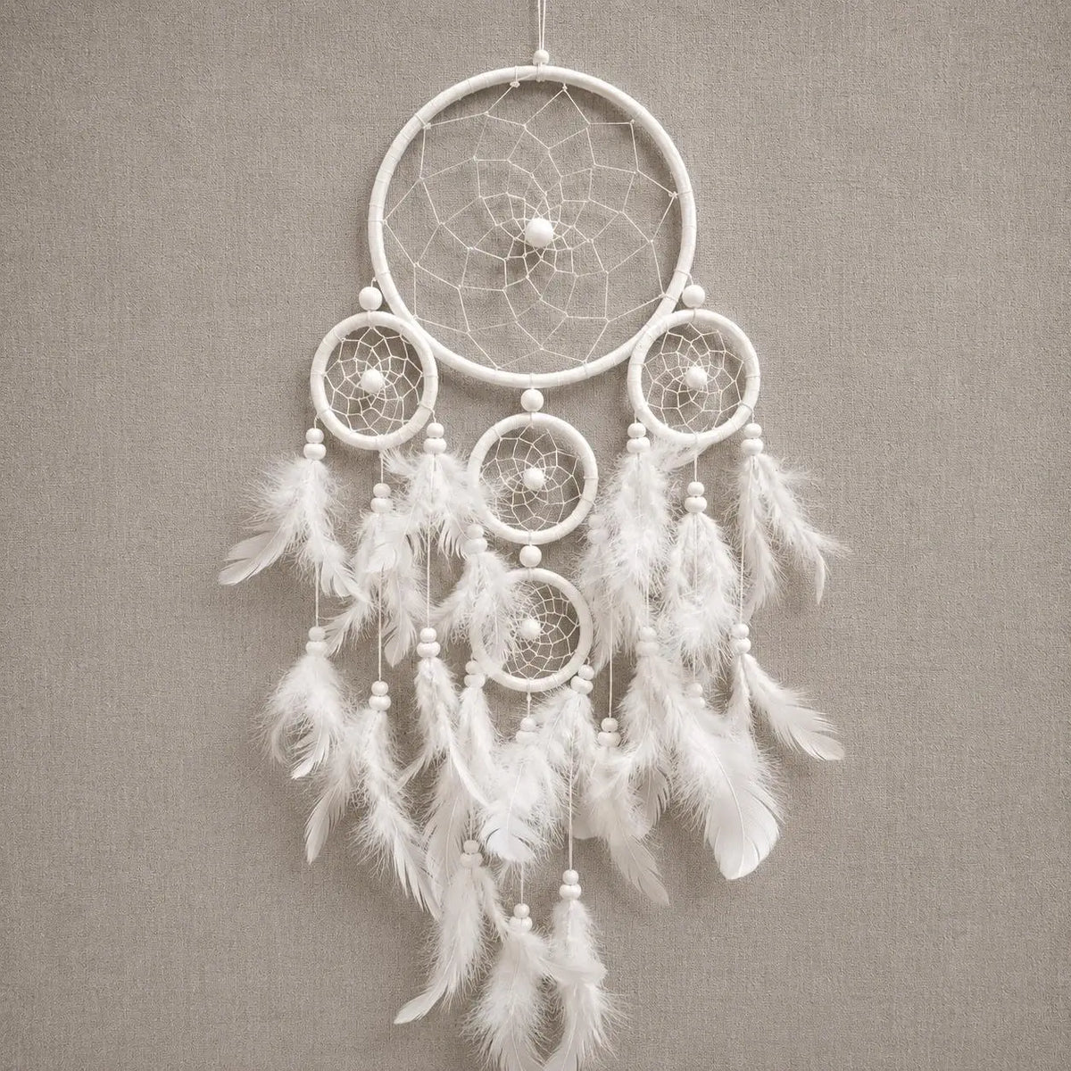 White dreamcatcher with feathers on a gray background