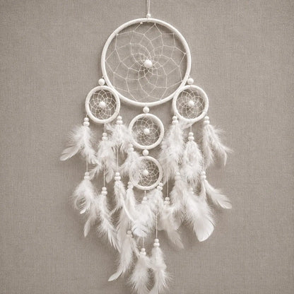 White dreamcatcher with feathers on a gray background