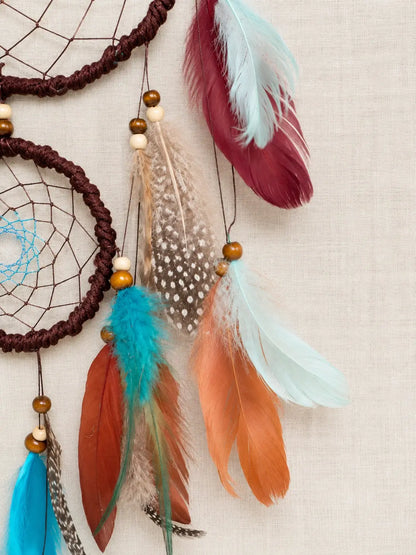 Dreamcatcher with feathers on a beige background