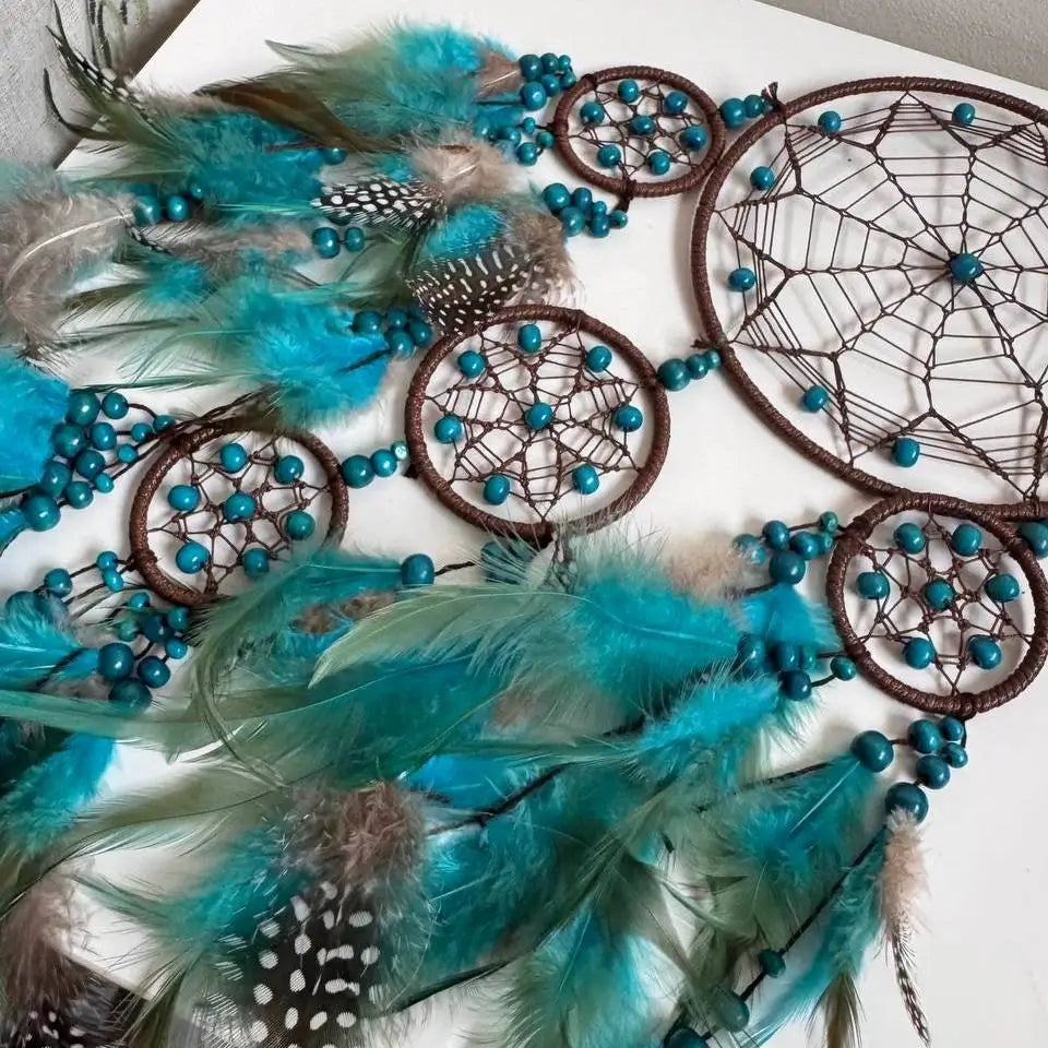 Dreamcatchers with turquoise feathers on a white background