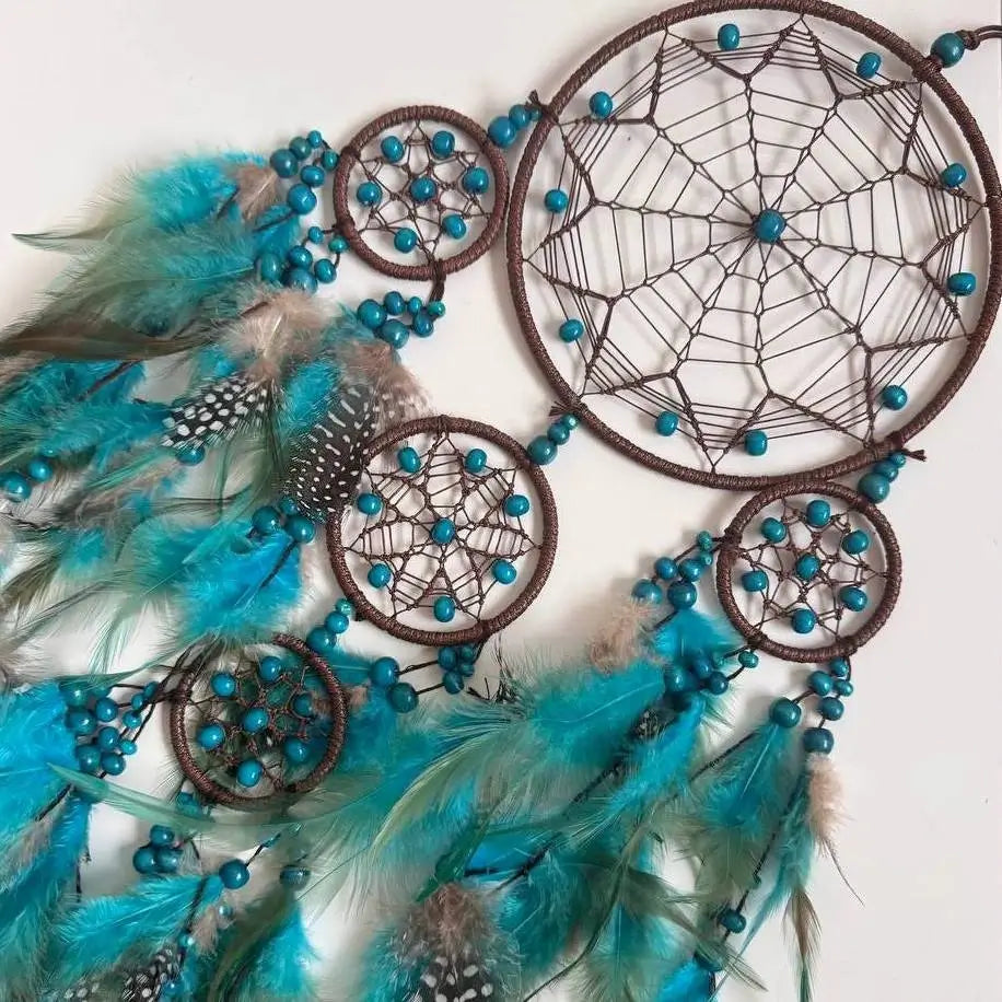 Dreamcatcher with turquoise feathers and beads on a white background